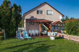 a house with chairs and a gazebo in the yard at Holiday home in Balatonmariafürdo 40847 in Balatonmáriafürdő