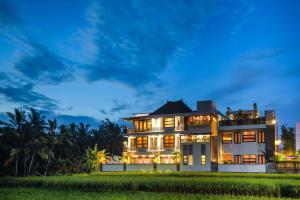 a house in the middle of a field at night at Luxe Villas Bali in Ubud