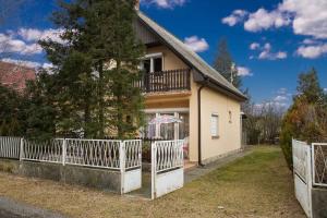 una casa con una recinzione bianca davanti di Holiday home in Balatonmariafürdo 36287 a Balatonmáriafürdő