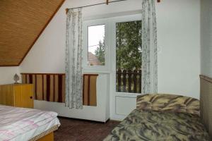 una camera da letto con una porta con una finestra e un letto di Holiday home in Balatonmariafürdo 36287 a Balatonmáriafürdő