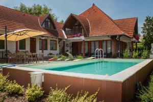 une maison avec une piscine dans la cour dans l'établissement Apartments in Balatonkeresztur 36528, à Balatonkeresztúr
