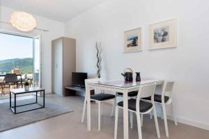 a white table and chairs in a living room at Apartment in Rabac 43550 in Rabac