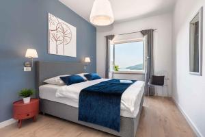 ラバックにあるApartment in Rabac 43550の青い壁と窓のあるベッドのある寝室