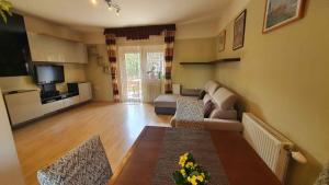 ein Wohnzimmer mit einem Sofa und einem Tisch in der Unterkunft Apartment in Zamardi - Balaton 20347 in Zamárdi