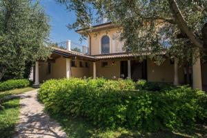 an old house with bushes in front of it at Mobilehomes in Pieve Vecchia - Norditalienische Seen 22044 in Manerba del Garda