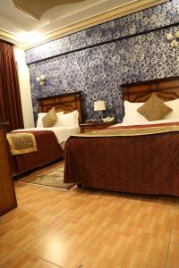 1 dormitorio con 2 camas y pared azul en Abha Hotel, en Abha