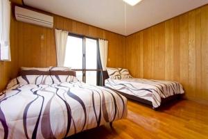 a bedroom with two beds and a window at Ocean Room YOMITAN in Yomitan +8 photos