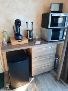 a counter with a microwave and a coffee maker at Le temps d'une pause ailleurs in Faumont