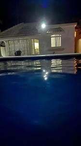 a swimming pool in front of a house at night at Shero Villa in Flic-en-Flac +3 photos