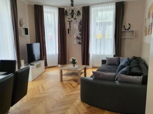 a living room with a black couch and a tv at Apartments-in-vienna in Vienna