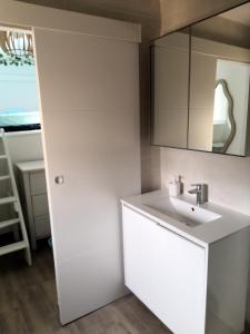 ein weißes Badezimmer mit einem Waschbecken und einem Spiegel in der Unterkunft spacieux logement vieil antibes climatisé 5 minutes plages in Antibes