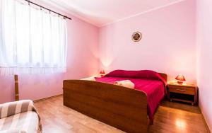 Un dormitorio con una cama roja y una ventana. en Apartment in Vrbnik - Insel Krk 13594, en Vrbnik