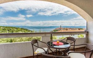 Una mesa y sillas en un balcón con vista al agua. en Apartment in Vrbnik - Insel Krk 13594, en Vrbnik 10 fotos más