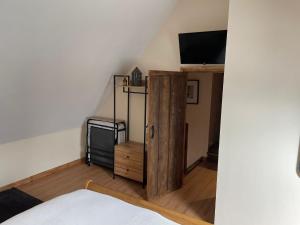 a bedroom with a bed and a tv on a wall at Buttercup Cottage at The Old Tractor Barn in Brackley