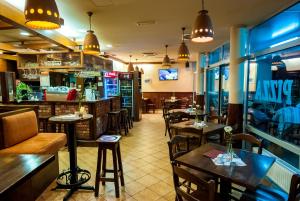 a restaurant with tables and chairs and a bar at Apartments and Studios Perunika in Moravske Toplice