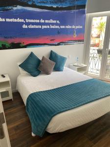a bedroom with a large bed with blue pillows at Guest House Stories in Beja