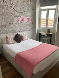 a bedroom with a bed with a red and white blanket at Guest House Stories in Beja