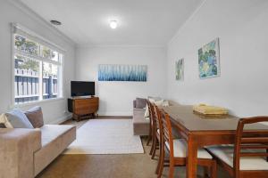 sala de estar con mesa y sofá en Lovely 3BR House In Seaside Area, en Williamstown