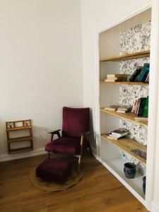 sala de estar con silla y estante para libros en Appartement « Le B » à Baccarat, en Baccarat