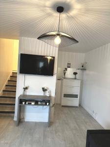 a living room with a flat screen tv and a ceiling at Jolie appartement duplex 2 min gare-Disney et paris 15 min in Noisy-le-Grand