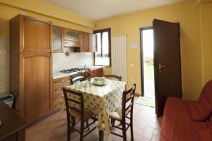 a kitchen with a table and chairs in a room at Il poggio dei tre contadini in Ponte Felcino