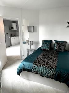 a white bedroom with a large bed and a kitchen at Jolie appartement duplex 2 min gare-Disney et paris 15 min in Noisy-le-Grand