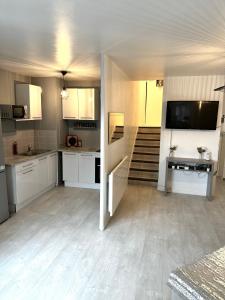 a large kitchen with white cabinets and a television at Jolie appartement duplex 2 min gare-Disney et paris 15 min in Noisy-le-Grand