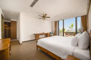 a bedroom with a white bed with a ceiling fan at VernalHome Boutique Danang in Danang
