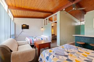 una habitación de hotel con dos camas y una mesa en Aaryn Court Motel, en Rotorua