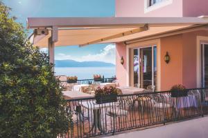 a balcony of a house with a table and chairs at Hotel Villa Europa in Gargnano