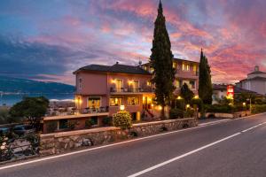 una casa al lado de un camino al anochecer en Hotel Villa Europa en Gargnano