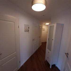 a room with a hallway with white walls and a light fixture at Seestern in Grömitz