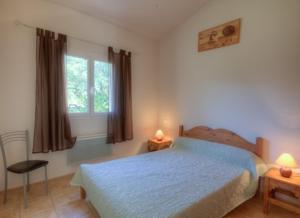 Schlafzimmer mit einem Bett und einem Fenster in der Unterkunft Les bergeries d'Ogliastrello in Figari