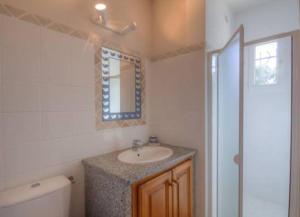 ein Bad mit einem Waschbecken und einem Spiegel in der Unterkunft Les bergeries d'Ogliastrello in Figari