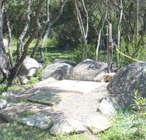einen Garten mit einigen Felsen und einigen Bäumen in der Unterkunft Les bergeries d'Ogliastrello in Figari