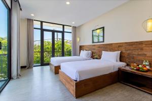 sypialnia z 2 łóżkami i dużym oknem w obiekcie Aki’s Pool Villa An Bang Beach w mieście Tân Thành (1)