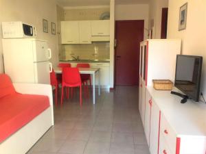eine Küche mit einem Tisch und roten Stühlen in einem Zimmer in der Unterkunft Apartment in Bibione 38277 in Bibione