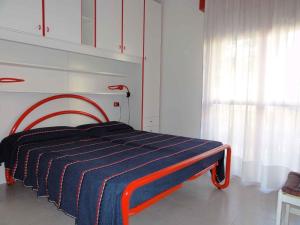 ein Schlafzimmer mit einem Bett mit einer blauen und orangen Decke in der Unterkunft Apartment in Bibione 38277 in Bibione