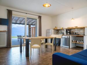 a kitchen and living room with a table and chairs at Oasi Da Vinci Apartments Lake Garda View in Tignale