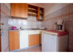 a kitchen with wooden cabinets and a white appliance at Studio in Starigrad-Paklenica 43596 in Starigrad-Paklenica
