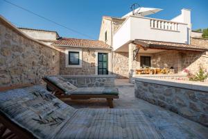 un patio con panchina e un edificio di Holiday home in Ljubac - Zadar Riviera 43105 a Ljubač