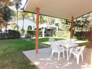 a white table and chairs on a patio at Holiday home in Bibione 41088 in Lo Stallone