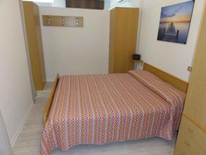 1 dormitorio con 1 cama con colcha de color naranja en Apartment in Bibione 36807, en Bibione