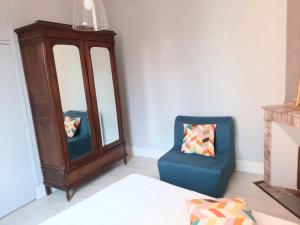 a bedroom with a chair and a mirror and a dresser at Appartement Pont des Catalans in Toulouse