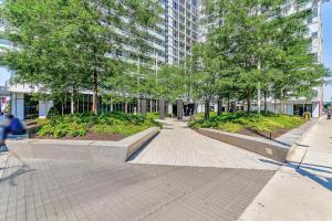 a walkway in a city with trees and a building at RivetStays - Quaint 1-Bedroom Steps from CN Tower, MTCC, Union Station in Toronto