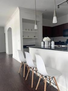 a kitchen with white chairs and a white counter at Luxe Houston by the Galleria, Free parking in Houston