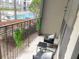 a balcony with two chairs and a swimming pool at Luxe Houston by the Galleria, Free parking in Houston
