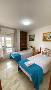 a hotel room with two beds and a window at Playa Huelin Apartamento in Málaga