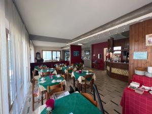 a dining room with green tables and chairs at Hotel Primavera in Desenzano del Garda