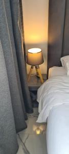 a bedroom with a bed and a lamp on a table at Luxueux Appartement DOWNTOWN RABAT in Rabat